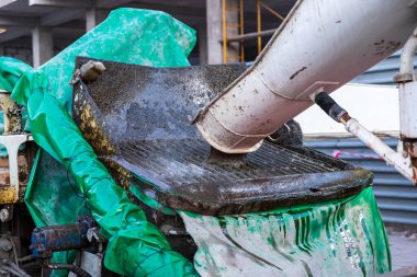 Beton karıştırıcı inşaat alanına beton yapıların güçlendirilmesi için beton pompa alıcısına beton dağıtıyor..