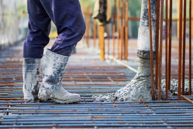 İnşaat alanındaki çelik takviye iskeletine beton dökülüyor..