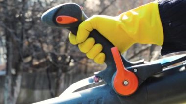Sırt çantalı bir motor püskürtücü STIHL SR450 'nin bahçe püskürtücü başlığının tetiğe yakın çekimi. Almaty, Kazakistan - 23 Mart 2023