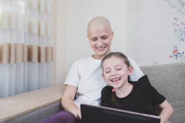 Çocuk kız, kemoterapiden sonra onkoloji teşhisi koyarak annesiyle vakit geçiriyor. Aile destek kavramı.