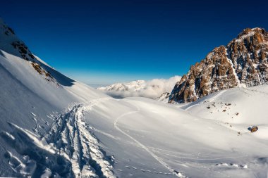 Etkileyici Kış Dağı Manzarası: Kazakistan Almaty Bölgesindeki Orta Asya Dağlarının Arkasındaki Görkemli Bulutlar Yüksek İrtifa Yürüyüş Patikası.