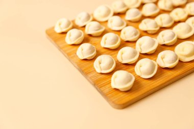 Yarı pişmiş hamur köfteleri ahşap bir tahtanın üzerinde düzgünce duruyor..