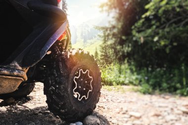 Büyük agresif ATV off-road bisiklet tekerleği doğanın pitoresk arka planına karşı macera istiyor..