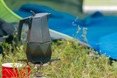 Açık havada bir fincan zengin kahve demlemek. Huzurlu ve huzurlu bir ortamda, bir kamp sobasında kahve demlemek.