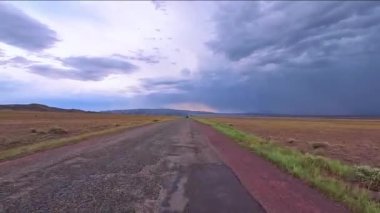 Orta Asya 'dan gelen bu sakin manzarada kaygı verici fırtına bulutları yükselirken, verimli tarlalarda sessiz bir yol esiyor. Kazakistan doğa parkı. 