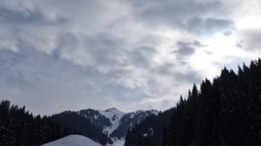 Karla kaplı dağların nefes kesici manzarasını deneyimleyin bulutlu bir gökyüzü altında, kış manzarası için ideal, Kazakistan doğası, Almaty dağları