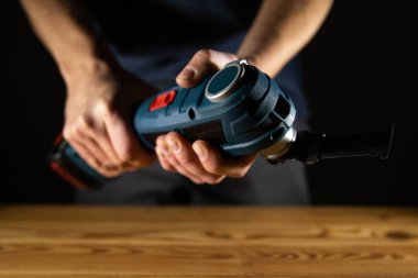 Çeşitli DIY görevleri ve projeleri için el bilgisayarlı elektrikli vibratör Multi Cutter aracını ustalıkla kullanan birinin kapatılması