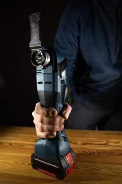 Çeşitli DIY projeleri ve ev onarımları için etkili bir kablosuz güç Çoklu Kesici aracı kullanan bir kişi