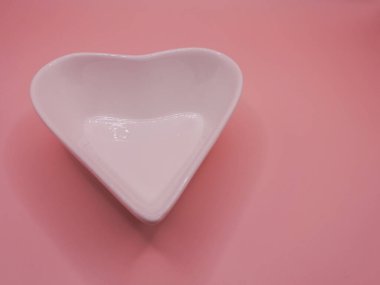 Sevgililer Günü için kırmızı arka planı olan kalp şeklinde seramik bir kalp. Noel, düğün ve aşk gibi farklı kutlamalar için dekore edilmiş..