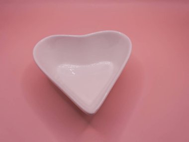 Sevgililer Günü için kırmızı arka planı olan kalp şeklinde seramik bir kalp. Noel, düğün ve aşk gibi farklı kutlamalar için dekore edilmiş..