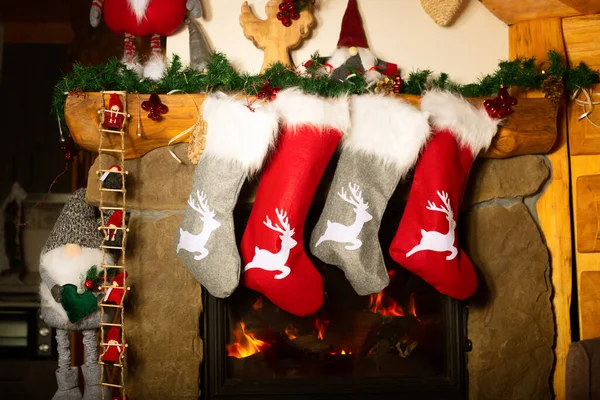圣诞袜挂在燃烧的壁炉上的照片 — 图库照片