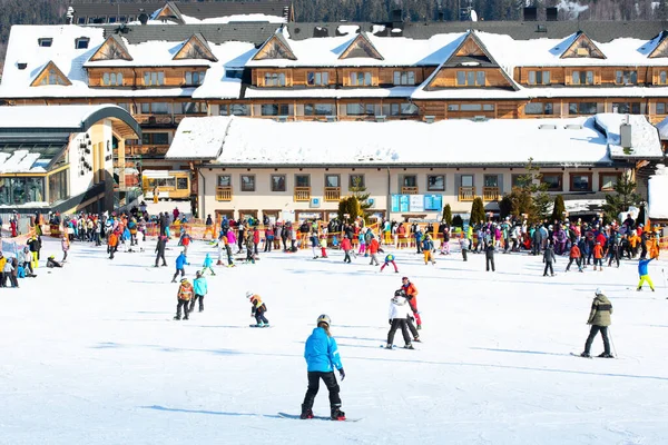 Bialka Tatrzanska, Polonya - 12 Şubat 2023: Tatra Dağlarındaki Bania Kayak İstasyonu. Turistler ve aşağı kayak. Kayak pistinin hazırlanması için gerekli ekipman. Geleneksel binalar