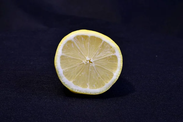 Eine Halbe Gelbe Saftige Zitrone Liegt Auf Dunklem Hintergrund — Stockfoto