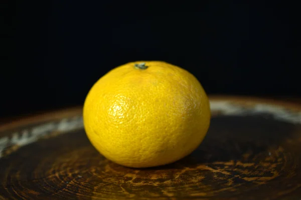 Een Rijpe Gele Mandarijn Ligt Een Platte Kleiplaat — Stockfoto