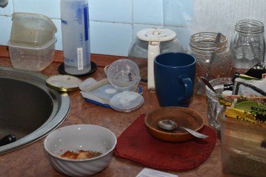 Mutfak masasında rastgele duran sayısız çanak çömlek, tabak, bardak, kaşık ve kavanoz..