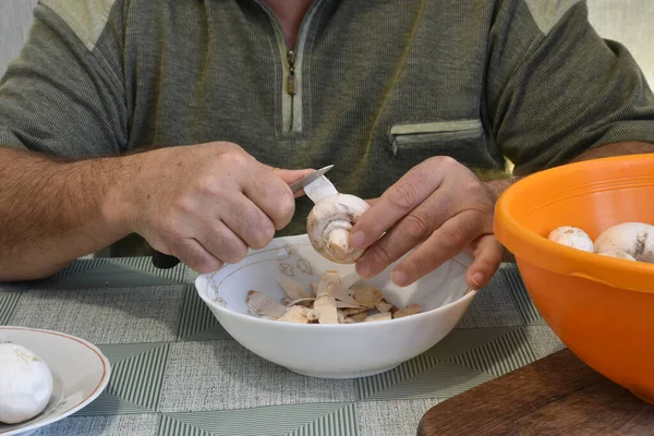 Ein Mann Sitzt Einem Tisch Und Reinigt Champignon Pilze Mit — Stockfoto