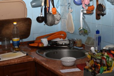 Lavabonun yanındaki mutfak masasında çanak çömlek var..