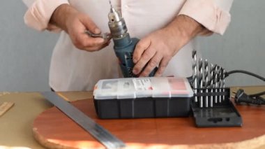 İşçi matkabın içine sıkıştırılmış matkabı serbest bırakır ve anahtarı elleriyle çıkarır..