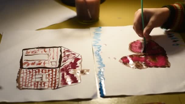 视频显示了一个男人和一个男孩的手 他们用画笔和颜料在纸上画了一些东西 — 图库视频影像