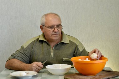 Bir adam masada oturuyor ve şampiyonları bıçakla soyuyor..