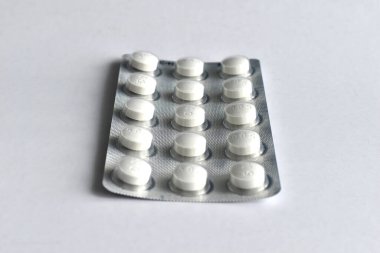 Beyaz bir masada büyük bir ilaç paketi var, yan görünüm..