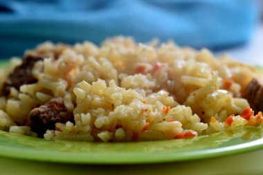 Kaynamış pirinci yakın plan et ve havuç parçalarıyla birlikte bir tabağa koy..