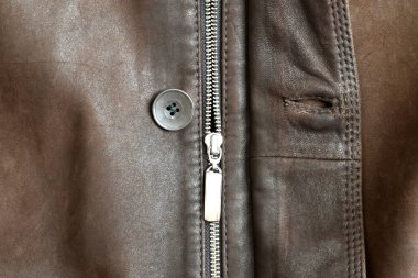 Metal zipper with lock and button. The zipper is sewn into the leather jacket.