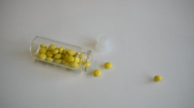 The bottle of medicine falls on the table, the medicine crumbles.