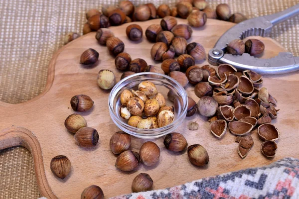 In the picture, hazelnuts, whole, split, shell, kernels lie on the table.