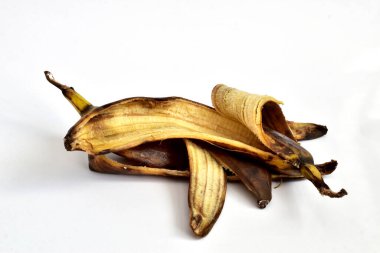 A discarded rotten banana peel lies on a white background.