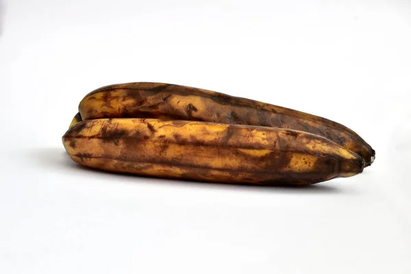 Két Túlérett Vagy Megereszkedett Banán Sötét Foltokban Fekszik Fehér Alapon — Stock Fotó