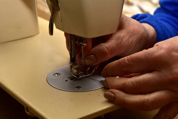 女裁缝的手在缝纫机针头上打孔的特写镜头 — 图库照片