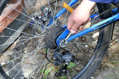 Çilingir eli, çilingir anahtarıyla bisiklet sürgüsünü sıkıyor..