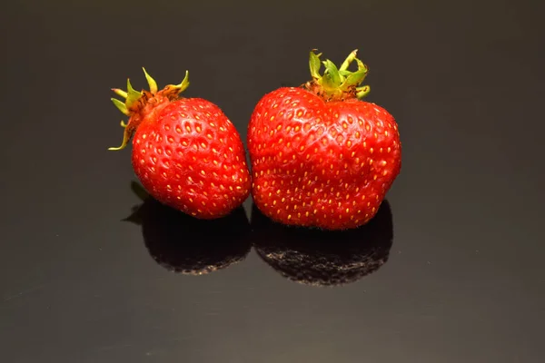 Zwei Rote Erdbeeren Mittelgroß Liegen Auf Schwarzem Hintergrund — Stockfoto