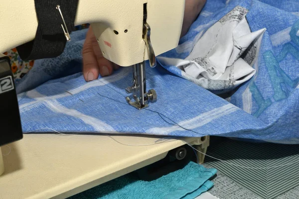 在主题桌上 有一台缝纫机 针底下有一块蓝色的织物 — 图库照片