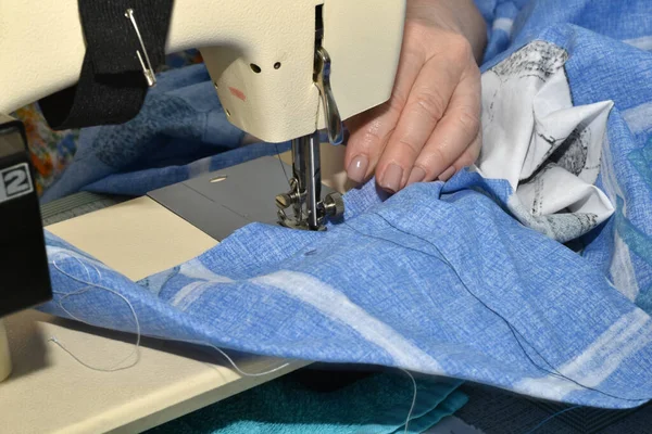女裁缝的手放在她用缝纫机缝制的织物上 — 图库照片