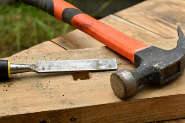 Tahtada bir keski, bir çekiç, bir marangoz aleti var..