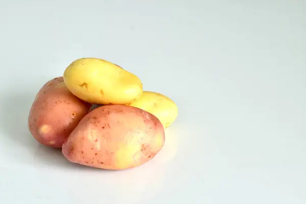 Ένα Μάτσο Νεαρές Πατάτες Ροζ Και Λευκά Λουλούδια Βρίσκονται Λευκό — Φωτογραφία Αρχείου