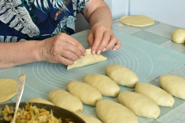 Fırıncı hamur içine dolgu koyar ve turtanın kenarlarını birbirine bağlar..