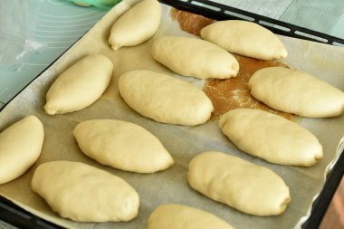 Pişirmeye hazır bir kaç tatlı turta, bir tepside uzanmak, üst manzara.