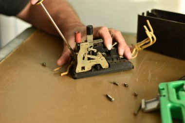 Elektrikçi, akımın üç aşamasıyla çalışan bir elektrik makinesinin iç mekanizmasını onarmak için tornavida kullanır..