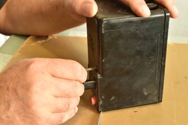 Bir elektrikçinin elinin AP50 'nin üç aşamalı elektrikli makinesinin kapağına cıvata yerleştirirken görüntüsü.