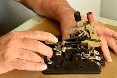 Bir elektrikçi üç aşamalı çalışan bir elektrik makinesinin iç mekanizmasını inceler..