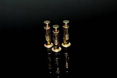 Siyah arkaplandaki üç demir cıvatadan yapılmış..