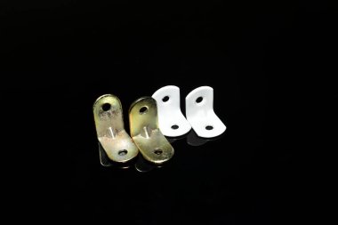 Siyah arka planda ahşap yapıları tutturmak için birkaç metal köşe vardır..