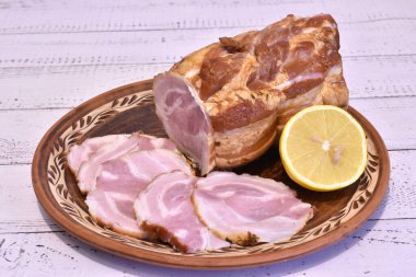 Resimde büyük bir parça köfte var. Parçaları kesilmiş, hepsi de kilden bir tabakta..