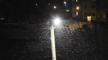 Kış. Kar fırtınası. Bir sokak lambasının ışığında, rüzgarın akıntılarının düşen karı nasıl uçurduğunu ve bir fırtına yarattığını görebilirsiniz..