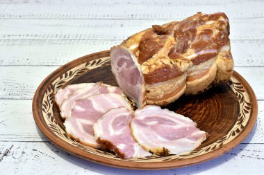 Bir parça haşlanmış domuz eti ve parçaları yuvarlak bir tabakta duruyor..