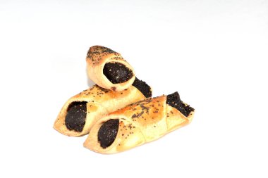 Beyaz arka planda, puf böreğinden fırınlanmış ve haşhaş tohumlarıyla dolu üç çörek..