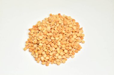 Soyulmuş ve kurutulmuş bezelye tohumları beyaz arka planda bir yığın içinde yatıyor..